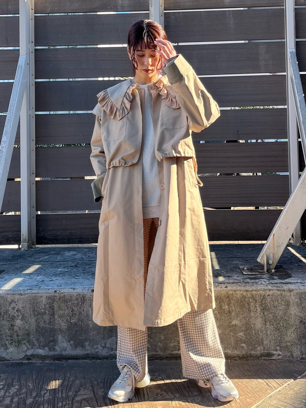 ベージュ系のトレンチコート、ベージュ系のその他パンツ、ホワイト系のスニーカーを着用したレディースの冬コーディネートの2枚目の写真