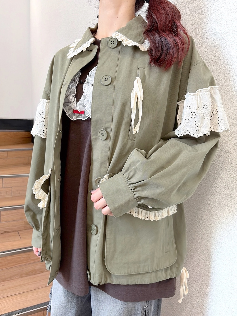 グリーン系のミリタリージャケット、ブラウン系のTシャツ/カットソー、グレー系のデニムパンツを着用したレディースの秋コーディネートの6枚目の写真