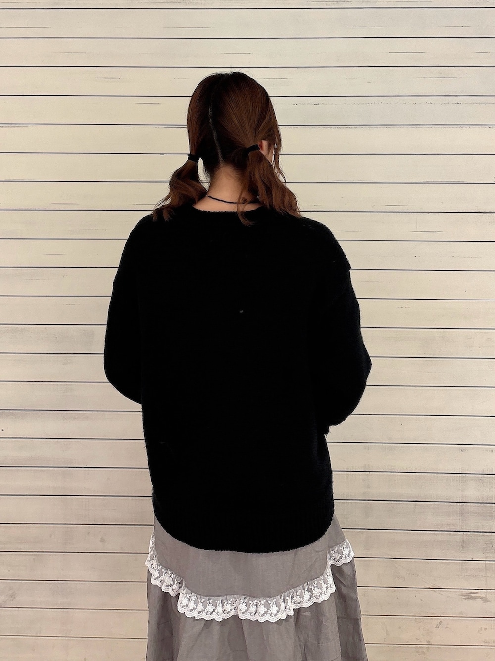 ブラック系のニット/セーター、グレー系のスカート、ブラック系のローファーを着用したレディースの秋コーディネートの4枚目の写真