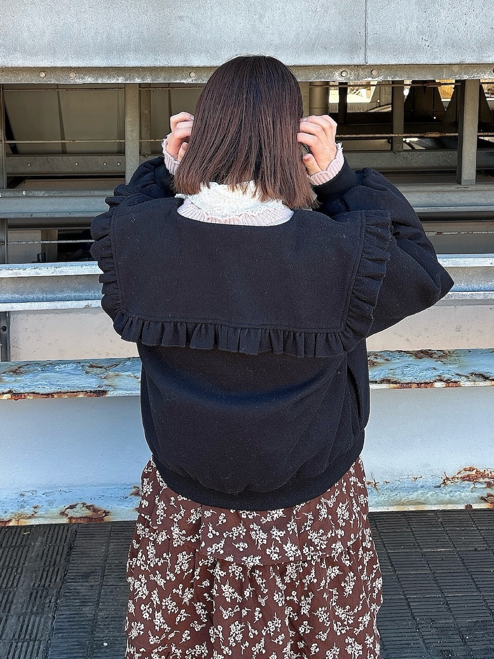 ブラウン系のワンピース、ブラック系のパンプス、ピンク系のカーディガン/ボレロを着用したレディースの冬コーディネートの4枚目の写真