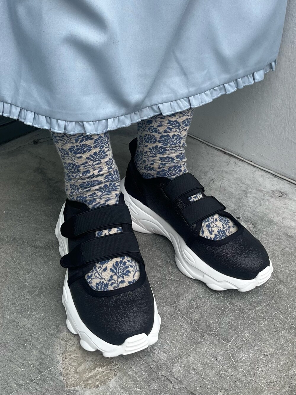 ブラック系のスニーカー、ブルー系のワンピース、ブラック系のニット/セーターを着用したレディースの冬コーディネートの3枚目の写真