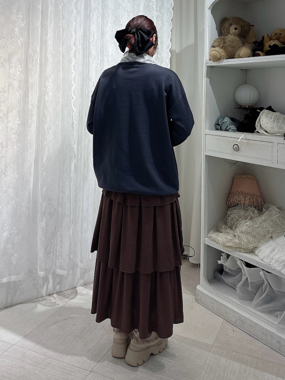 グレー系のスウェット、ブラウン系のトートバッグ、ブラウン系のスカートを着用したレディースの秋コーディネートの3枚目の写真