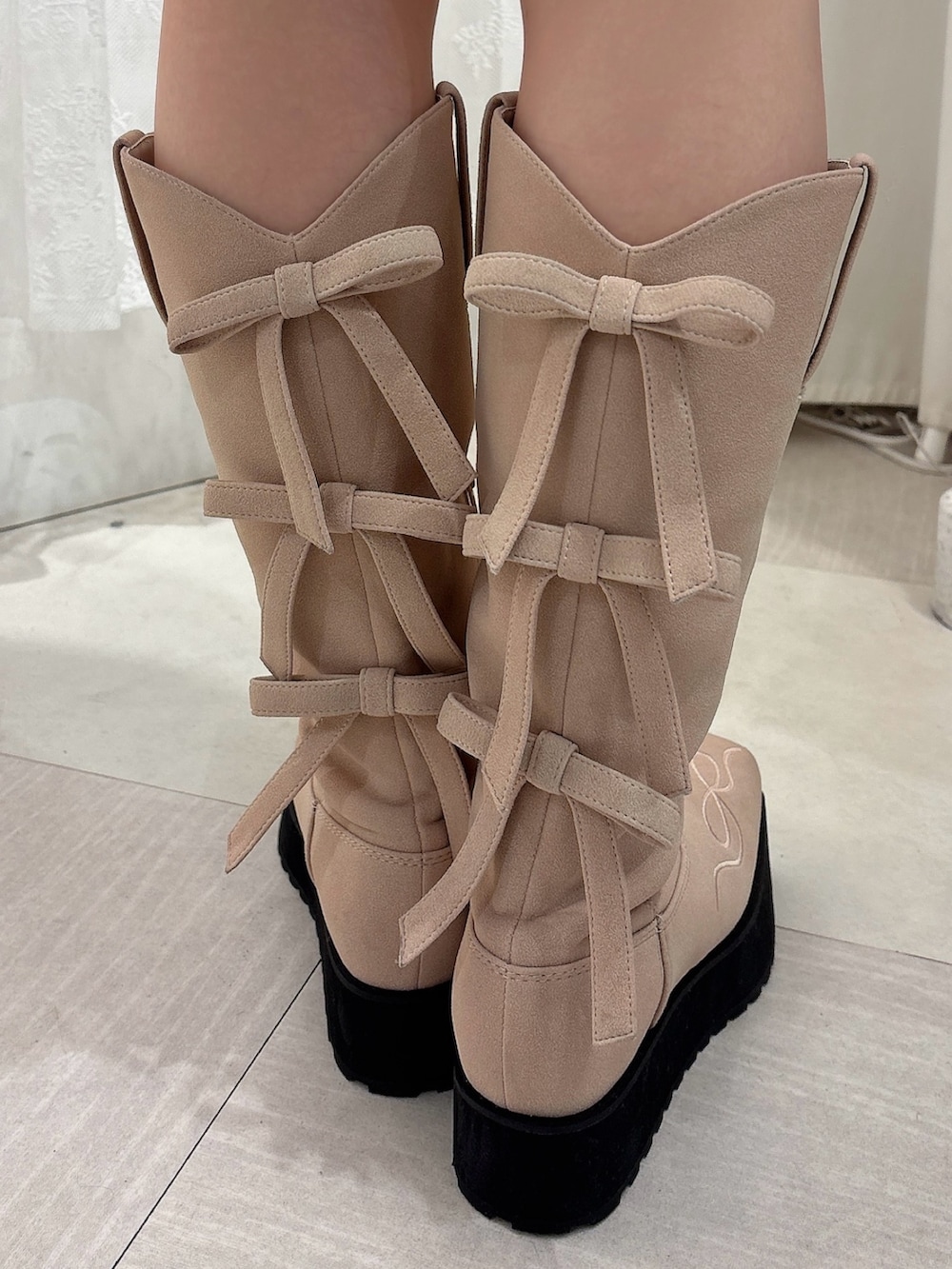 ピンク系のニット/セーター、ブラウン系のスカート、ピンク系のブーツを着用したレディースの秋コーディネートの7枚目の写真