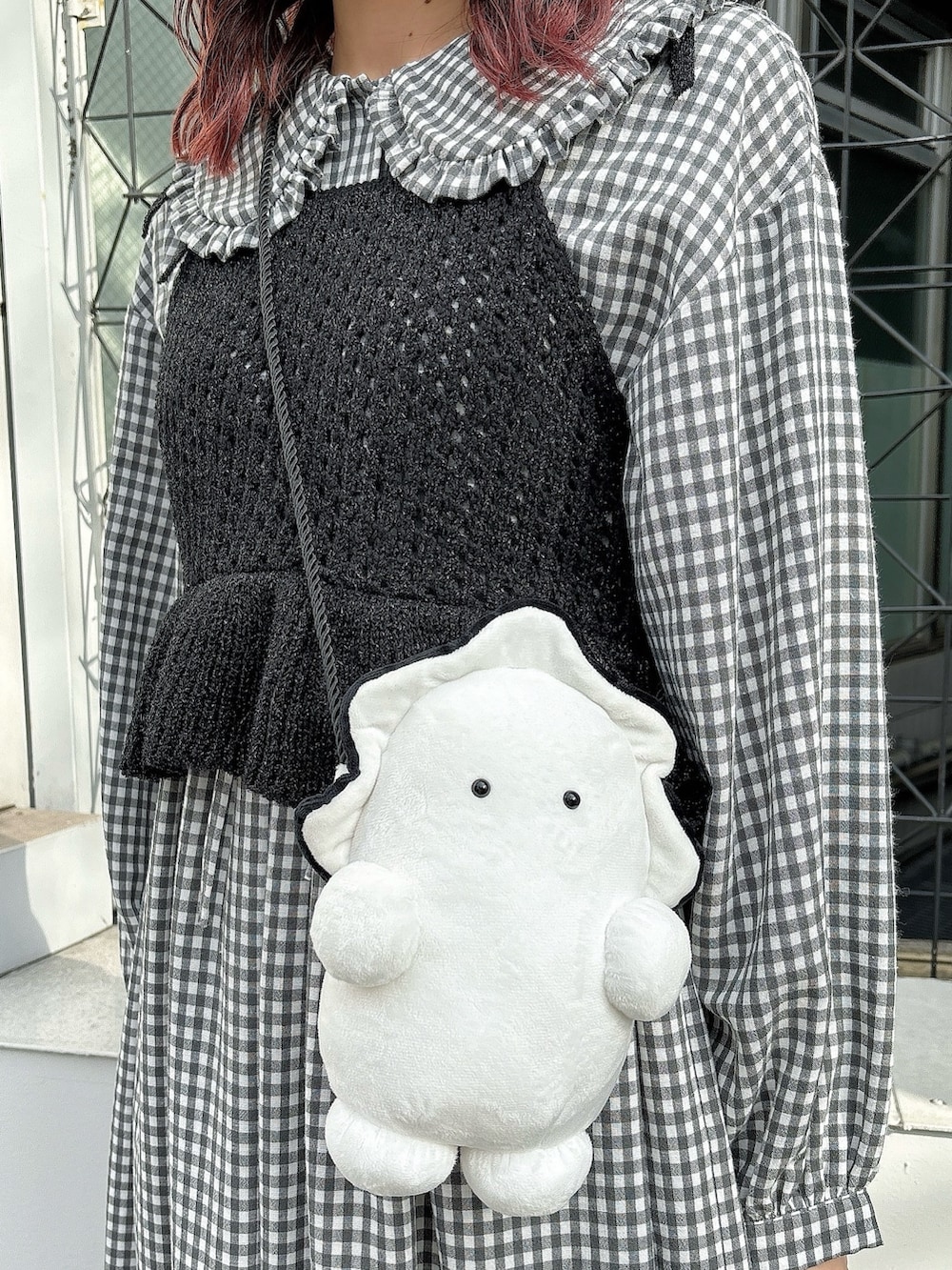 ホワイト系のショルダーバッグ、ブラック系のワンピース、ブラック系のキャミソールを着用したレディースの冬コーディネートの3枚目の写真