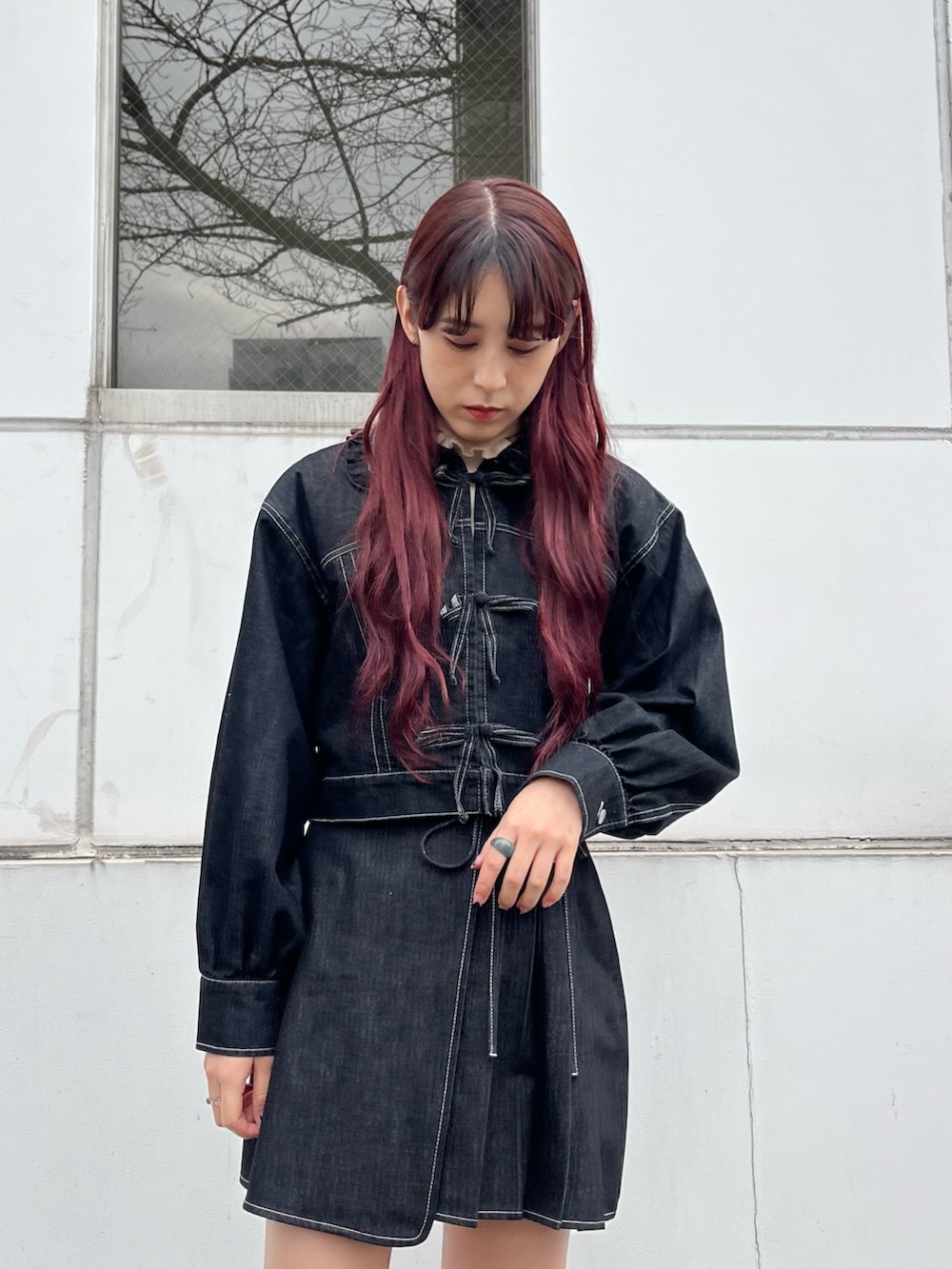 ブラック系のデニムジャケット、ブラック系のデニムスカート、ブラック系のパンプスを着用したレディースの冬コーディネートの2枚目の写真