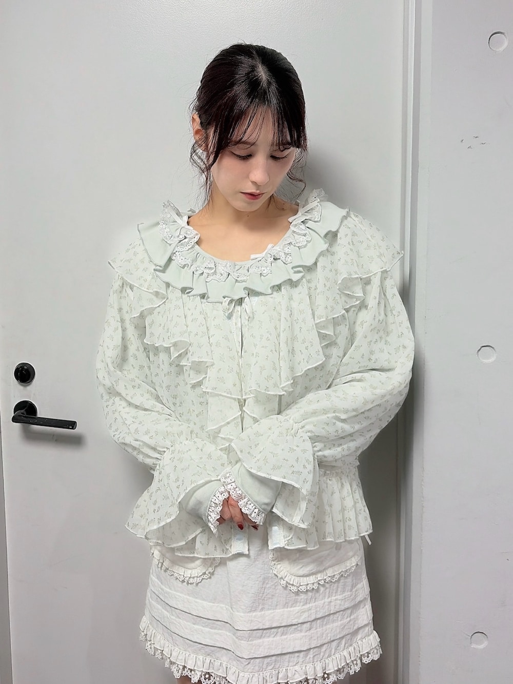 グリーン系のTシャツ/カットソー、ブルー系のカーディガン/ボレロ、ホワイト系のスカートを着用したレディースの冬コーディネートの3枚目の写真