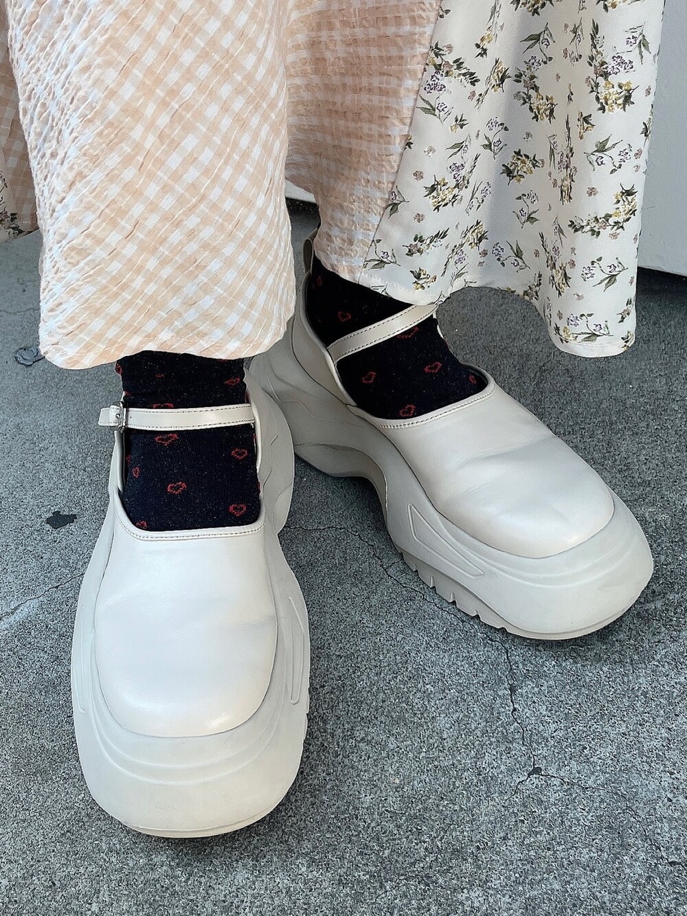 ホワイト系のハンドバッグ、ホワイト系のニット/セーター、ホワイト系のスカートを着用したレディースの秋コーディネートの3枚目の写真