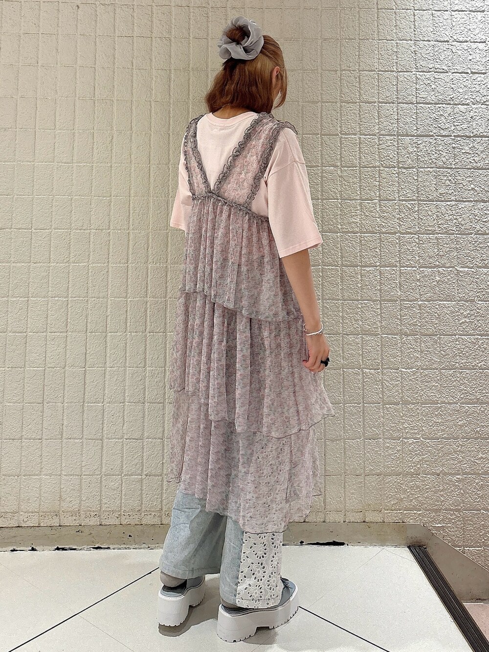 ピンク系のワンピース、ブルー系のデニムパンツ、ブルー系のサンダルを着用したレディースの夏コーディネートの2枚目の写真