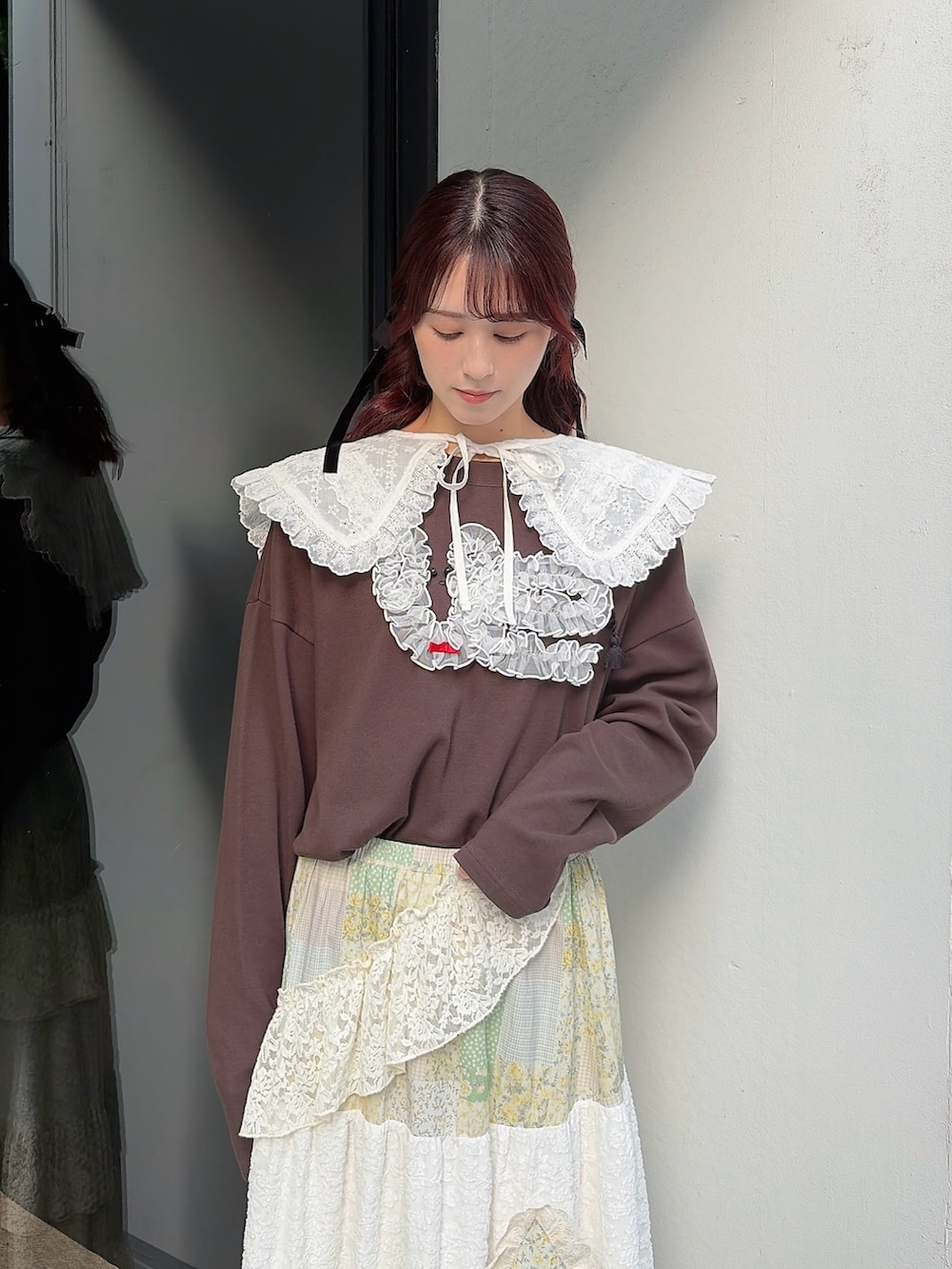 ブラウン系のTシャツ/カットソー、イエロー系のスカート、ホワイト系のブーツを着用したレディースの春コーディネートの3枚目の写真