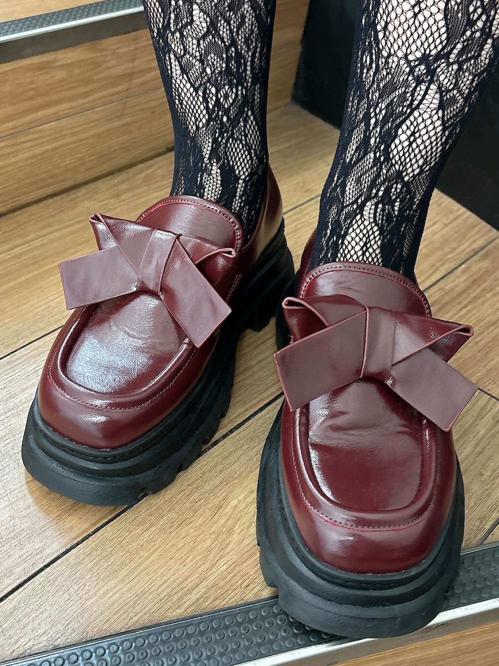 グリーン系のワンピース、ブラウン系のカーディガン/ボレロ、レッド系のローファーを着用したレディースの秋コーディネートの7枚目の写真