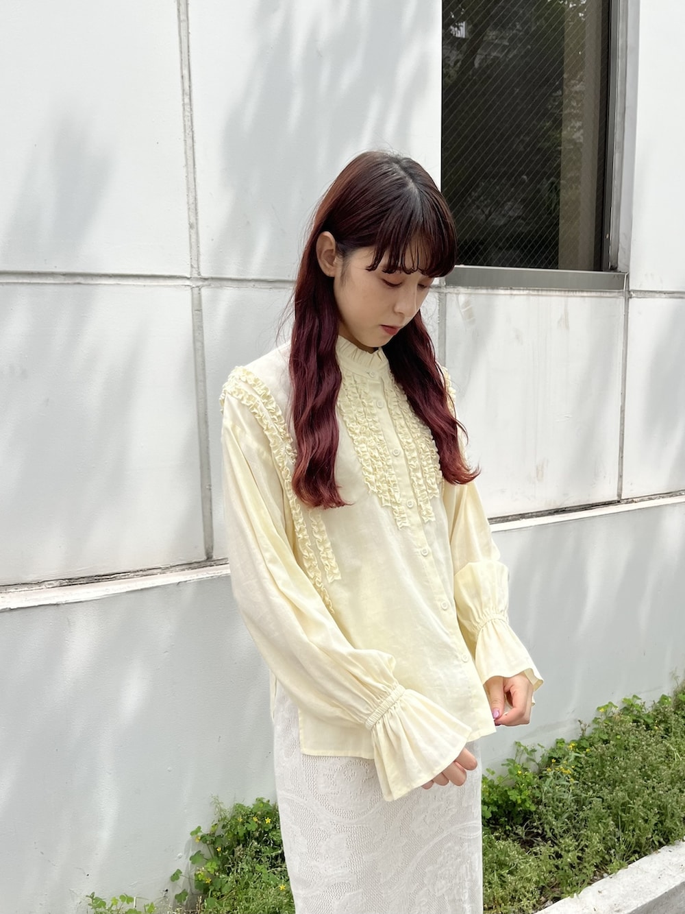 イエロー系のシャツ/ブラウス、ホワイト系のスカート、ベージュ系のトートバッグを着用したレディースの春コーディネートの3枚目の写真