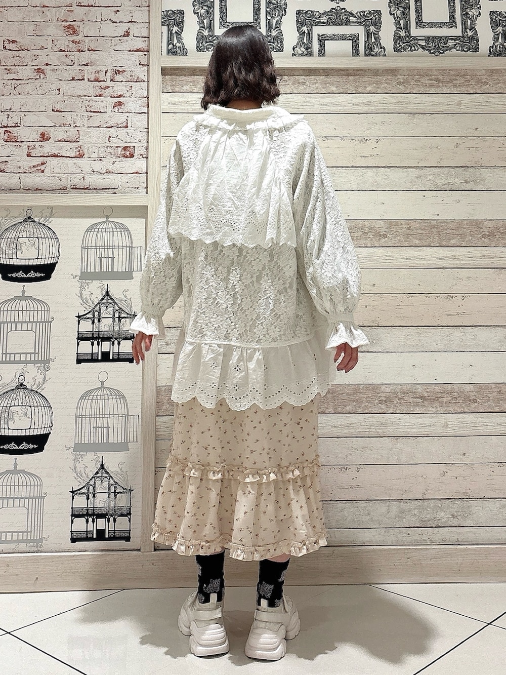 ホワイト系のテーラードジャケット、ホワイト系のワンピース、ホワイト系のスニーカーを着用したレディースの冬コーディネートの2枚目の写真