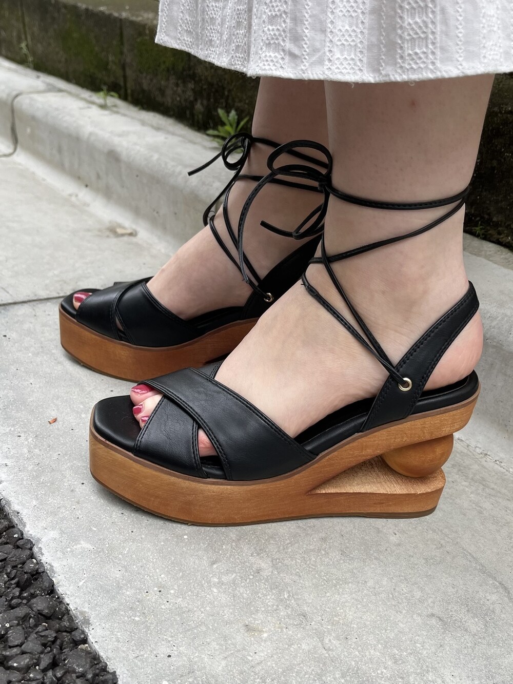 ホワイト系のワンピース、ブラック系のサンダル、ホワイト系のチュニックを着用したレディースの春コーディネートの2枚目の写真