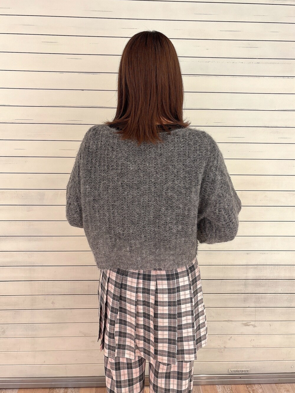 グレー系のニット/セーター、ブラック系のTシャツ/カットソー、ピンク系のスラックスを着用したレディースの秋コーディネートの4枚目の写真