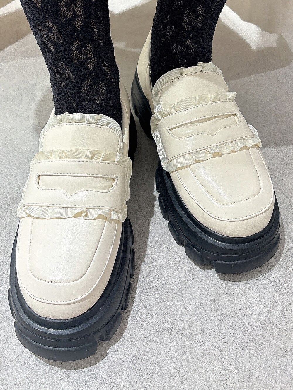 グレー系のニット/セーター、レッド系のスカート、ホワイト系のローファーを着用したレディースの秋コーディネートの7枚目の写真