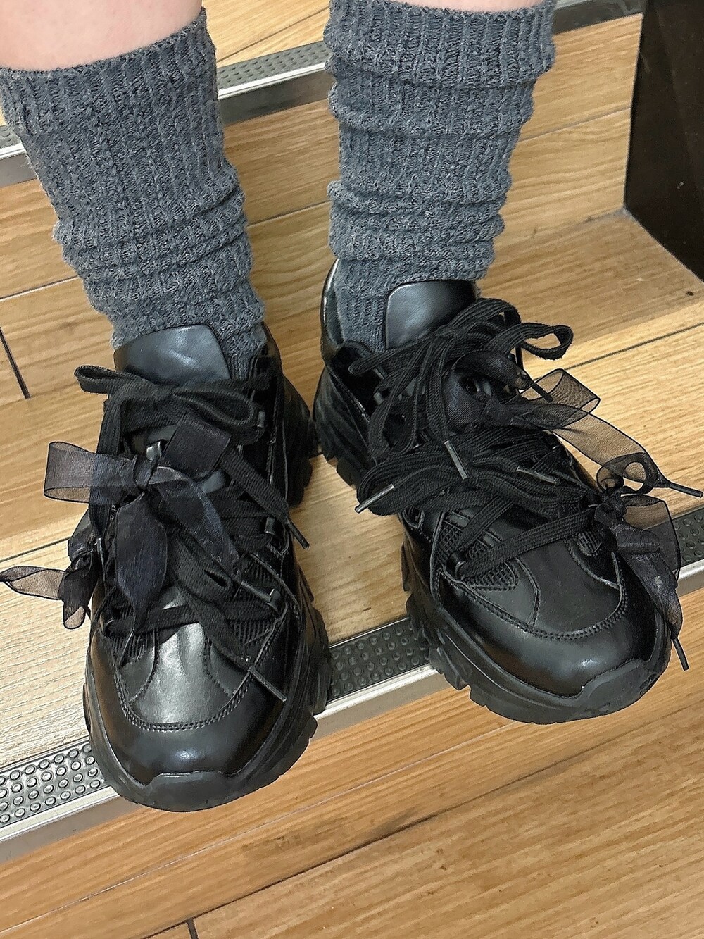 グレー系のワンピース、ブラック系のスニーカー、ピンク系のショルダーバッグを着用したレディースの冬コーディネートの4枚目の写真