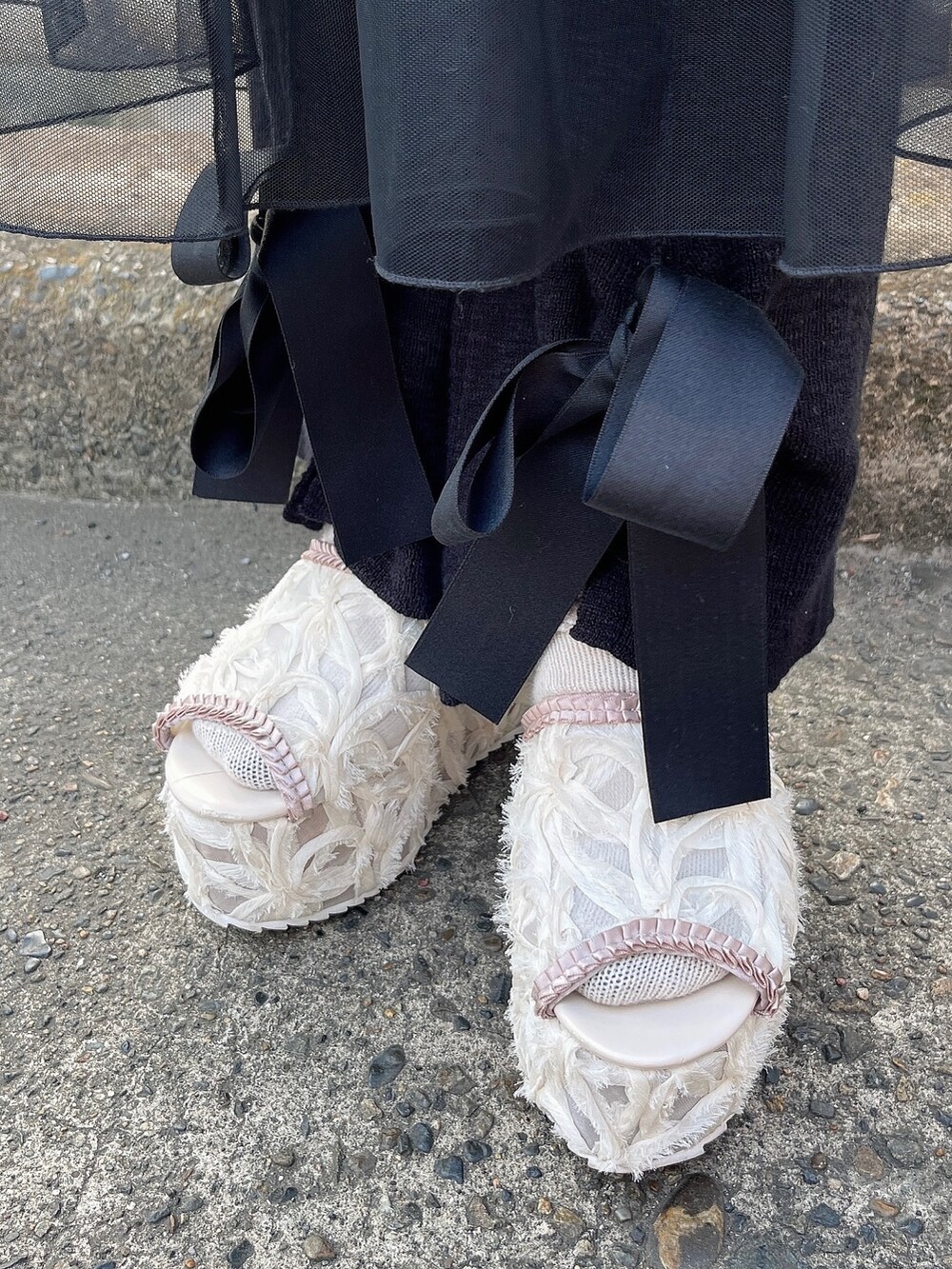 ブラック系のワンピース、ブラック系のスウェットパンツ、ピンク系のサンダルを着用したレディースの夏コーディネートの3枚目の写真