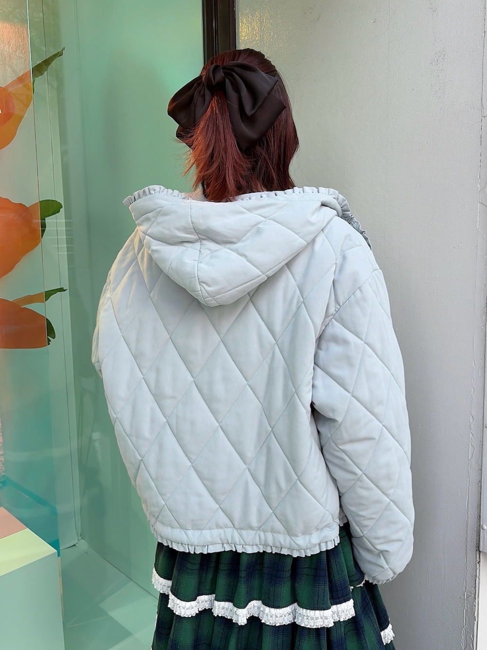 ブルー系のダウンジャケット/コート、ホワイト系のニット/セーター、グリーン系のスカートを着用したレディースの冬コーディネートの4枚目の写真