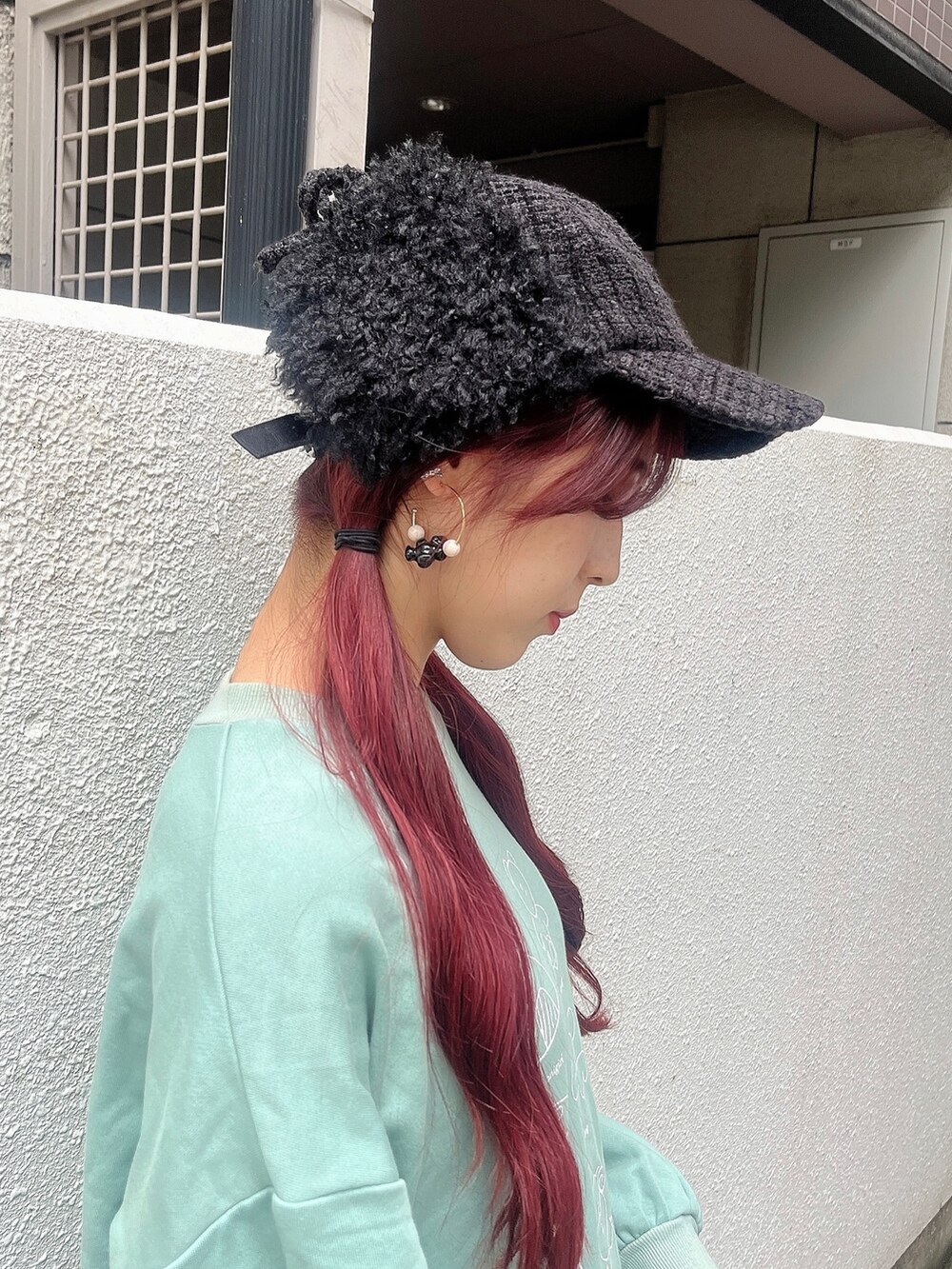 グリーン系のスウェット、ブラック系のスカート、ブラック系のブーツを着用したレディースの秋コーディネートの4枚目の写真