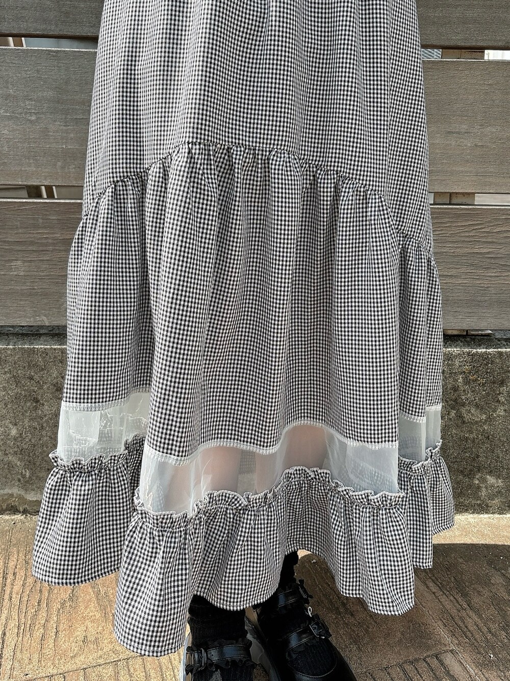 ブラック系のスカート、ホワイト系のTシャツ/カットソー、ブラック系のシャツ/ブラウスを着用したレディースの春コーディネートの5枚目の写真