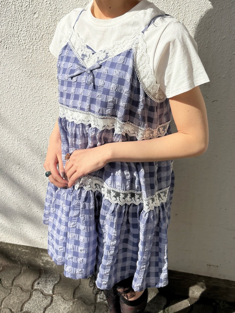 ブルー系のキャミソール、ホワイト系のTシャツ/カットソー、ブラック系のスカートを着用したレディースの春コーディネートの4枚目の写真