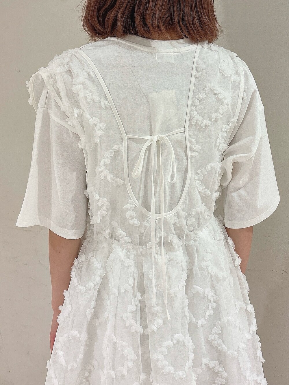 ピンク系のショルダーバッグ、ホワイト系のジャンパースカート、ホワイト系のTシャツ/カットソーを着用したレディースの夏コーディネートの7枚目の写真