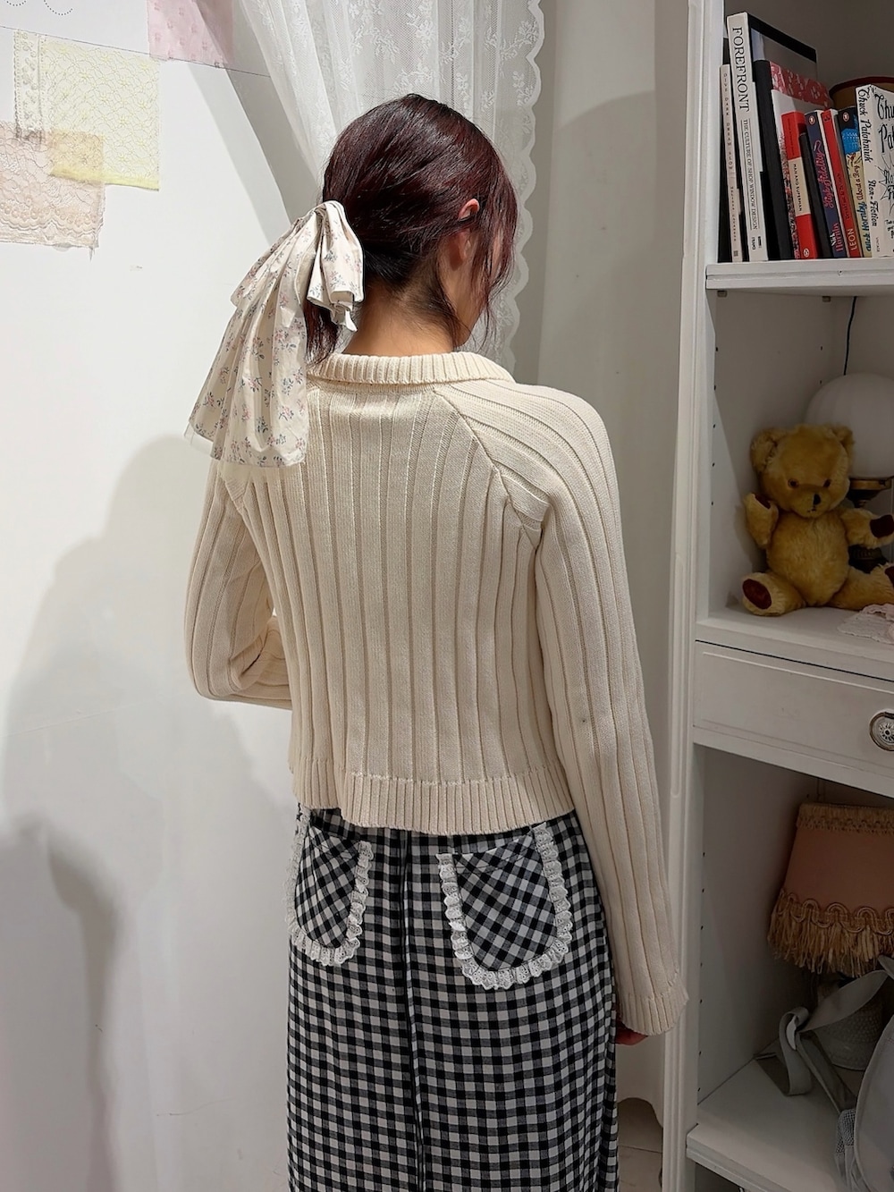 ホワイト系のカーディガン/ボレロ、ブラック系のスカート、ブラック系のスニーカーを着用したレディースの冬コーディネートの4枚目の写真