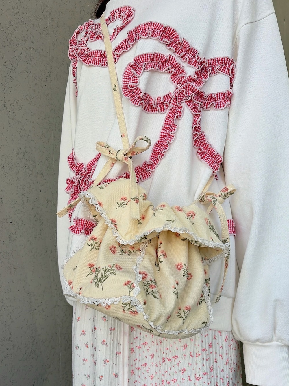 ホワイト系のスウェット、ホワイト系のショルダーバッグ、ピンク系のスカートを着用したレディースの冬コーディネートの5枚目の写真