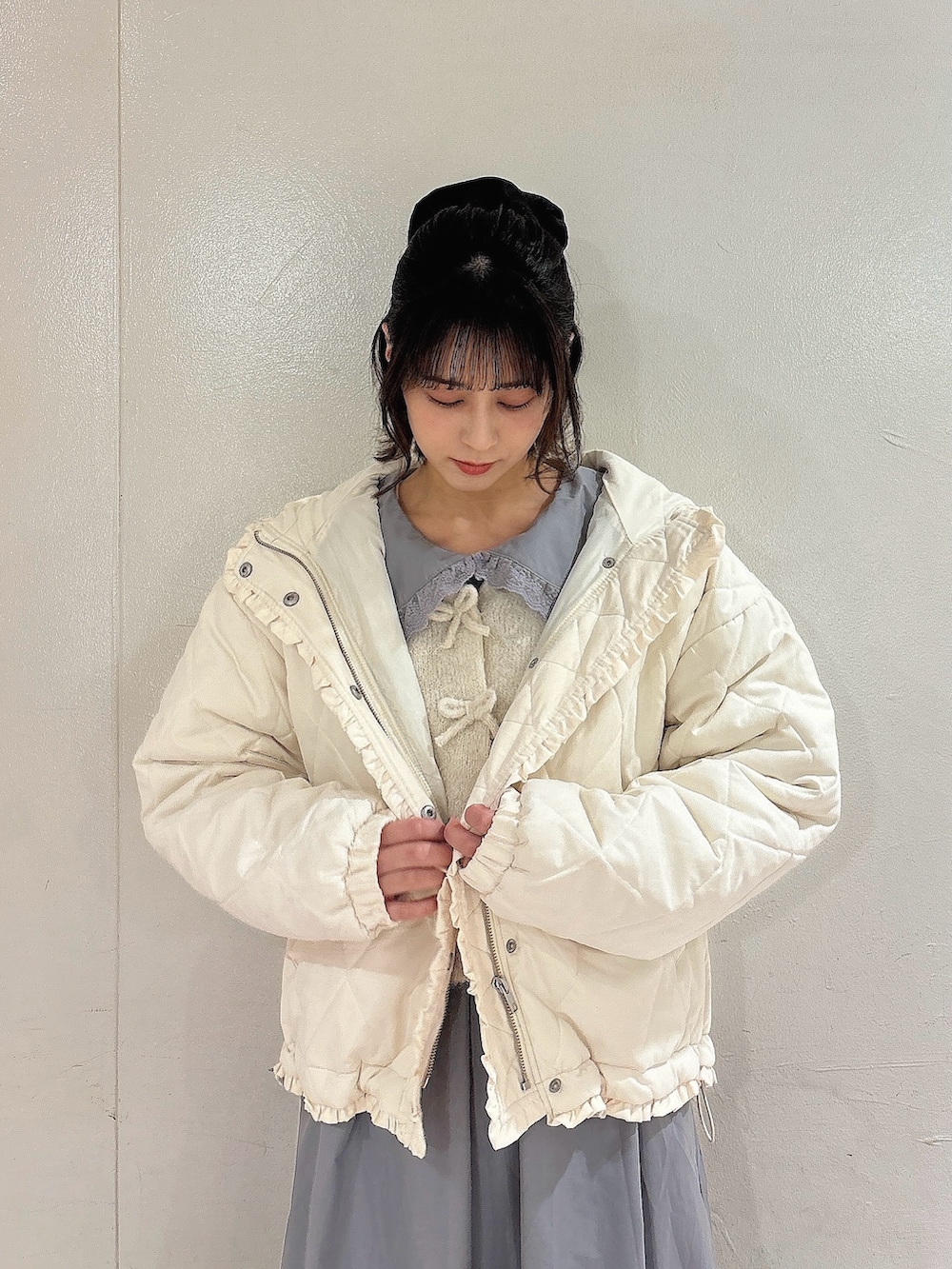 ホワイト系のダウンジャケット/コート、ホワイト系のカーディガン/ボレロ、グレー系のワンピースを着用したレディースの秋コーディネートの3枚目の写真