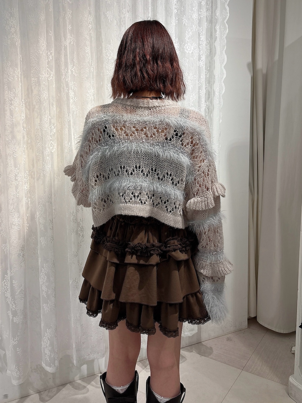 ブラウン系のスカート、ブラウン系のブーツ、グレー系のカーディガン/ボレロを着用したレディースの夏コーディネートの4枚目の写真