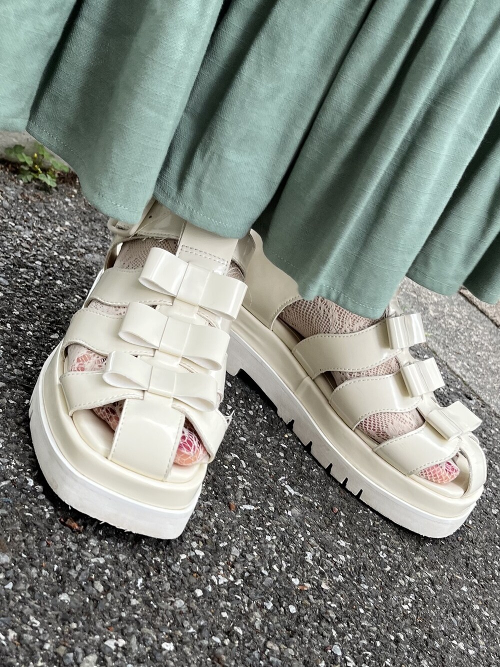 ホワイト系のトートバッグ、レッド系のサンダル、グリーン系のスカートを着用したレディースの春コーディネートの5枚目の写真