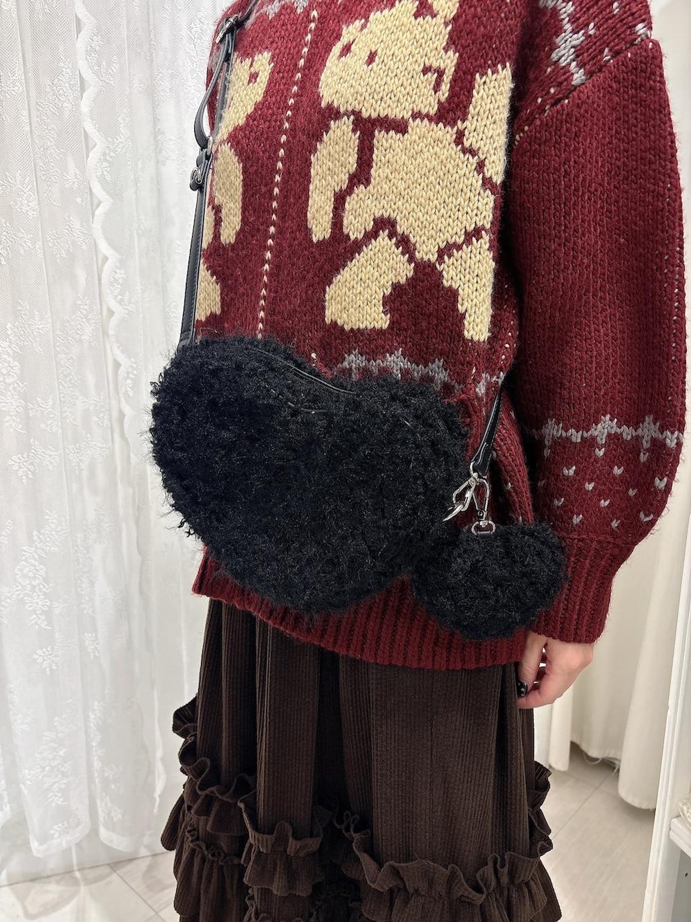 ブラウン系のスカート、ブラック系のショルダーバッグ、ホワイト系のスニーカーを着用したレディースの秋コーディネートの5枚目の写真