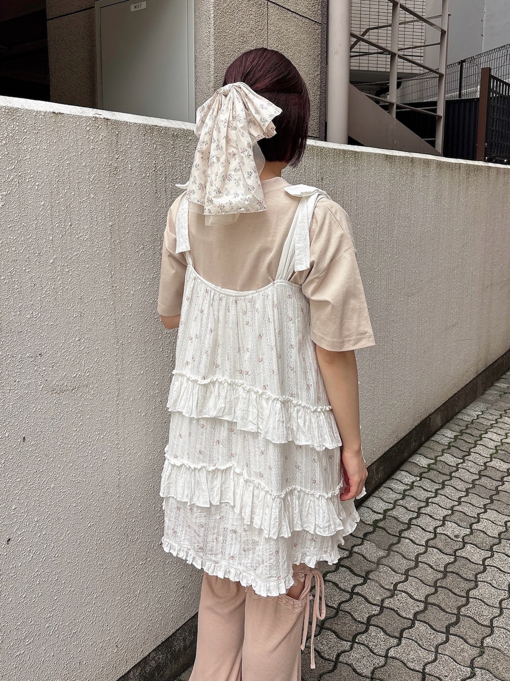 ピンク系のワンピース、ピンク系のスウェットパンツ、ホワイト系のサンダルを着用したレディースの夏コーディネートの4枚目の写真
