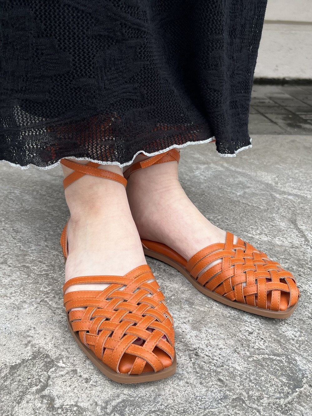 ブラック系のスカート、ホワイト系のTシャツ/カットソー、オレンジ系のパンプスを着用したレディースの春コーディネートの3枚目の写真