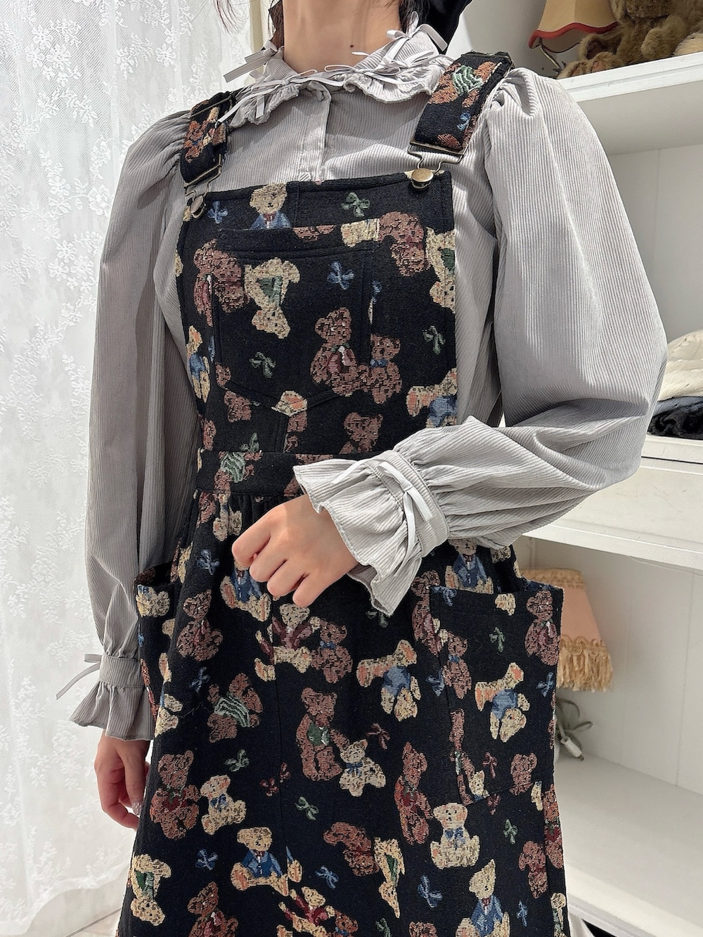 グレー系のシャツ/ブラウス、ブラック系のジャンパースカート、ブラック系のローファーを着用したレディースの秋コーディネートの5枚目の写真