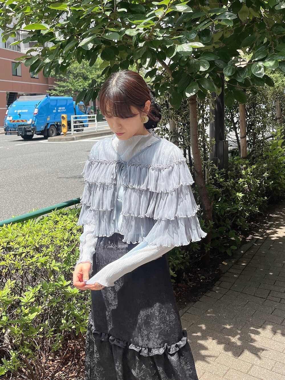 ブラック系のスカート、ブラック系のパンプス、ブルー系のTシャツ/カットソーを着用したレディースの夏コーディネートの2枚目の写真