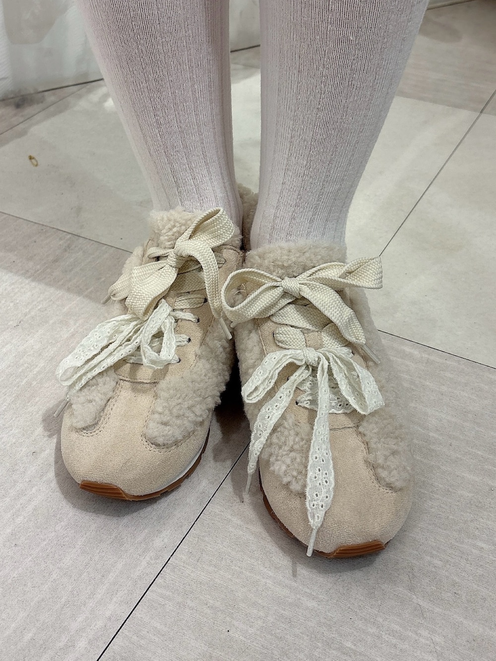 ピンク系のスウェット、グレー系のスカート、ホワイト系のスニーカーを着用したレディースの秋コーディネートの6枚目の写真