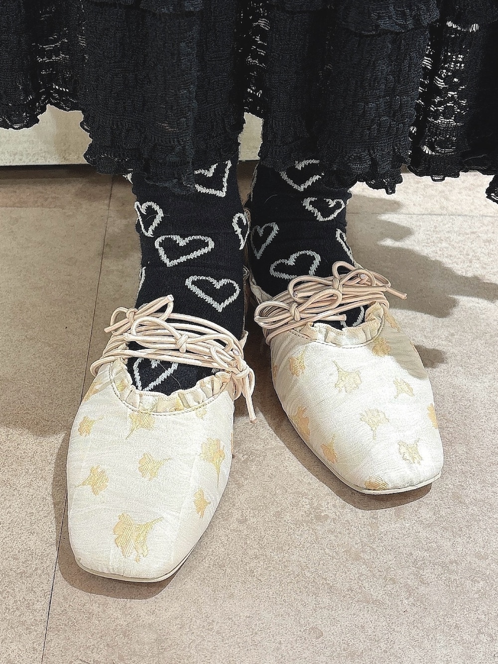 ブラック系のスカート、ブラック系のTシャツ/カットソー、ゴールド系のバレエシューズを着用したレディースの春コーディネートの7枚目の写真