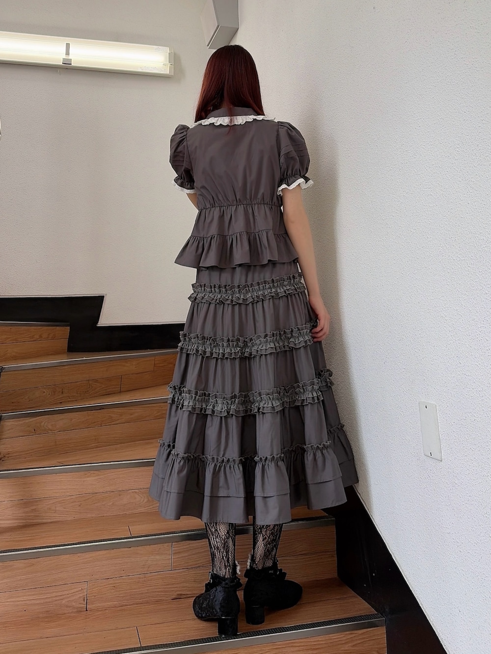 グレー系のシャツ/ブラウス、グレー系のスカート、ブラック系のパンプスを着用したレディースの夏コーディネートの2枚目の写真
