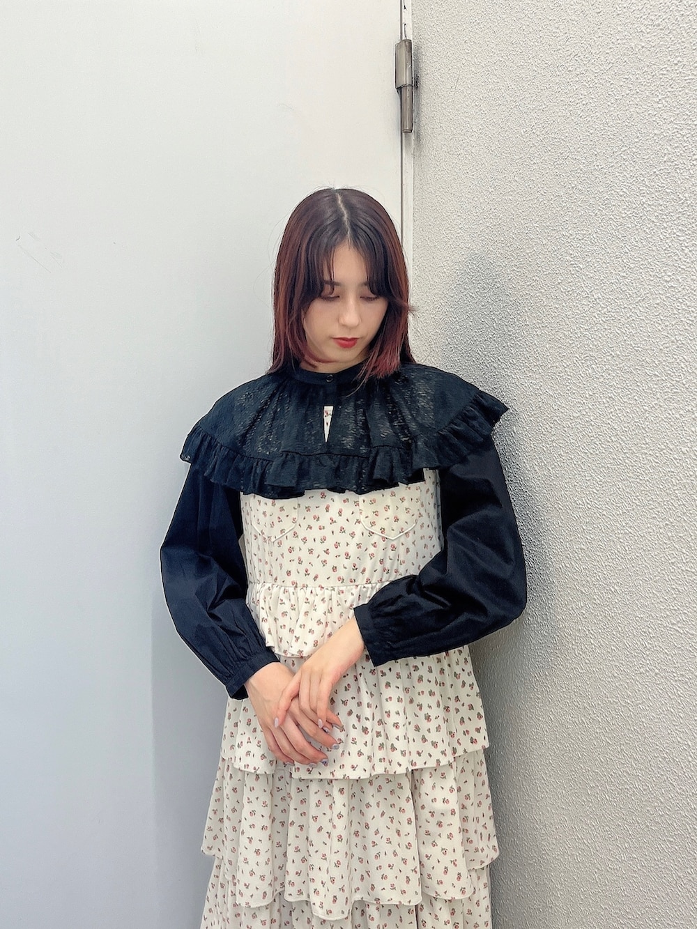 ブラック系のシャツ/ブラウス、ホワイト系のジャンパースカート、ホワイト系のパンプスを着用したレディースの秋コーディネートの2枚目の写真