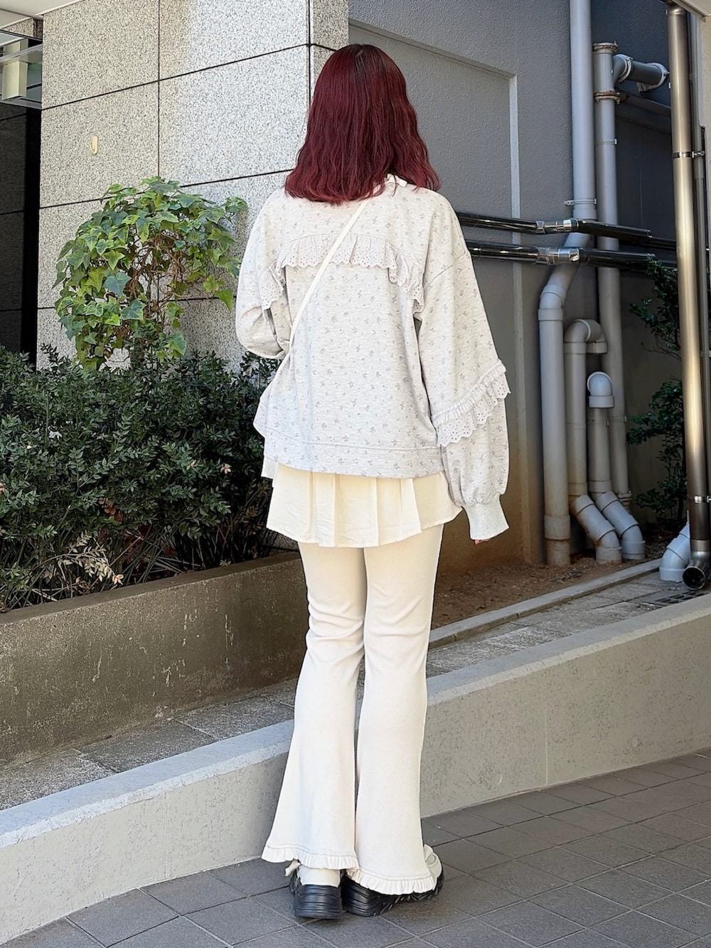 グレー系のスウェット、ホワイト系のショルダーバッグ、ホワイト系のスウェットパンツを着用したレディースの冬コーディネートの2枚目の写真