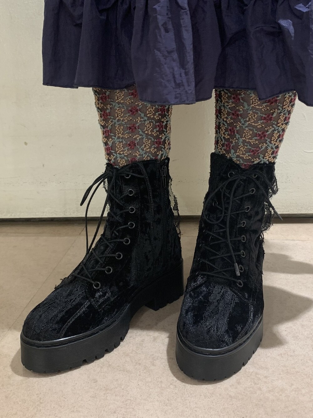 ブラック系のブルゾン、ブラック系のブーツ、ブルー系のワンピースを着用したレディースの冬コーディネートの3枚目の写真