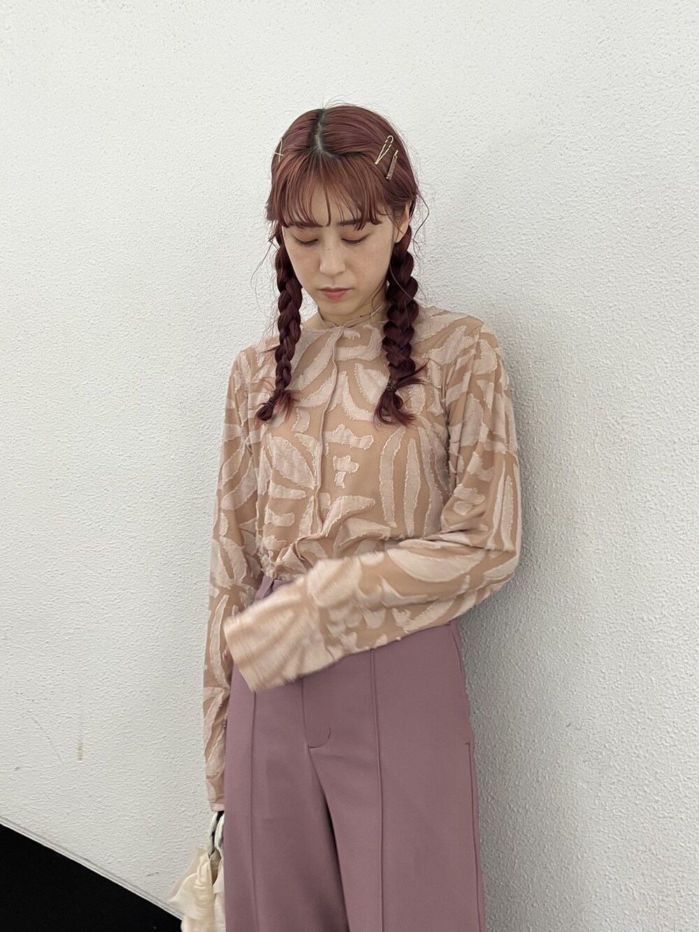 ホワイト系のハンドバッグ、ピンク系のスラックス、ホワイト系のサンダルを着用したレディースの夏コーディネートの2枚目の写真