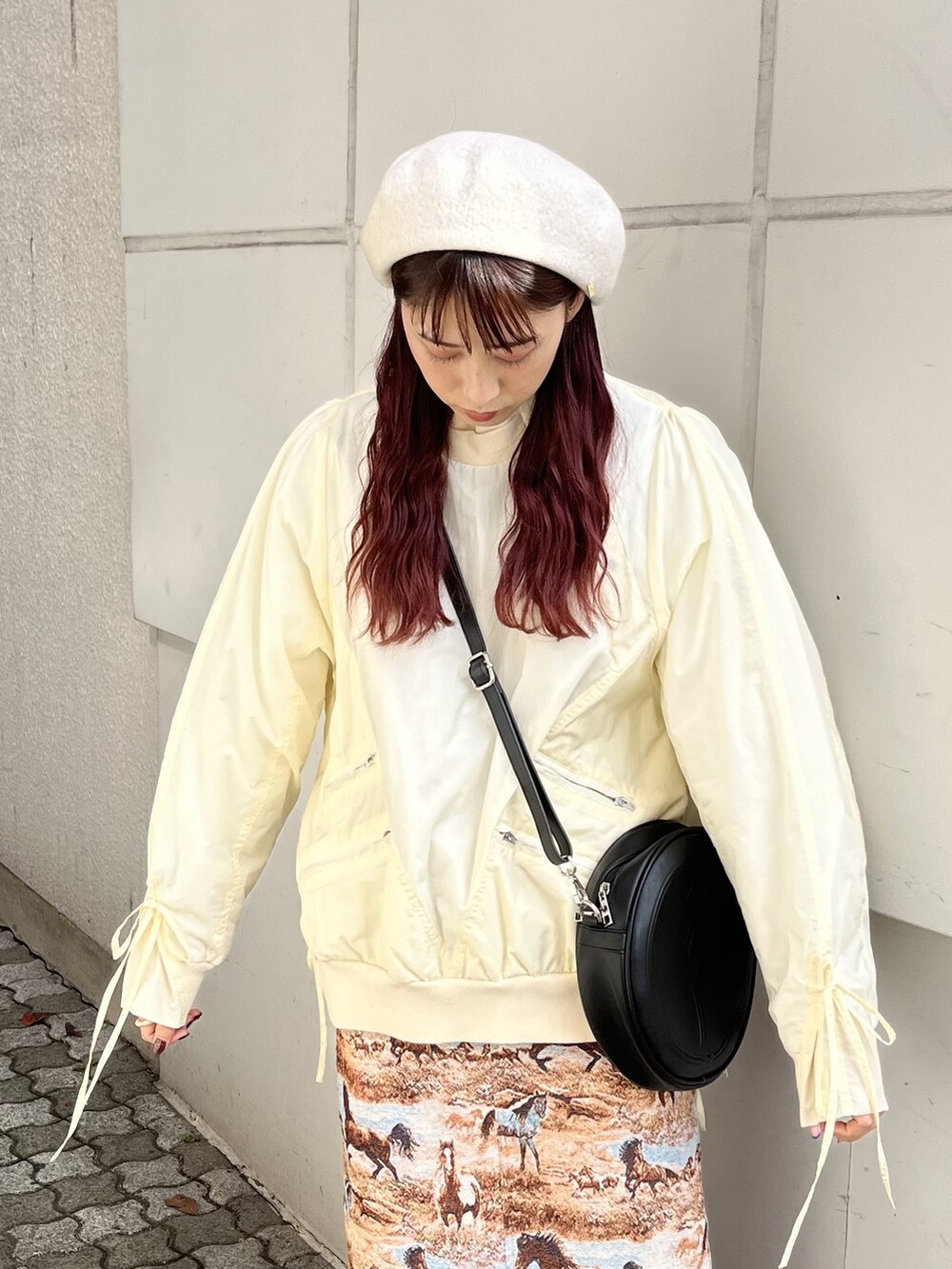 ブラック系のショルダーバッグ、ブラウン系のブーツ、ブラウン系のジャンパースカートを着用したレディースの冬コーディネートの2枚目の写真