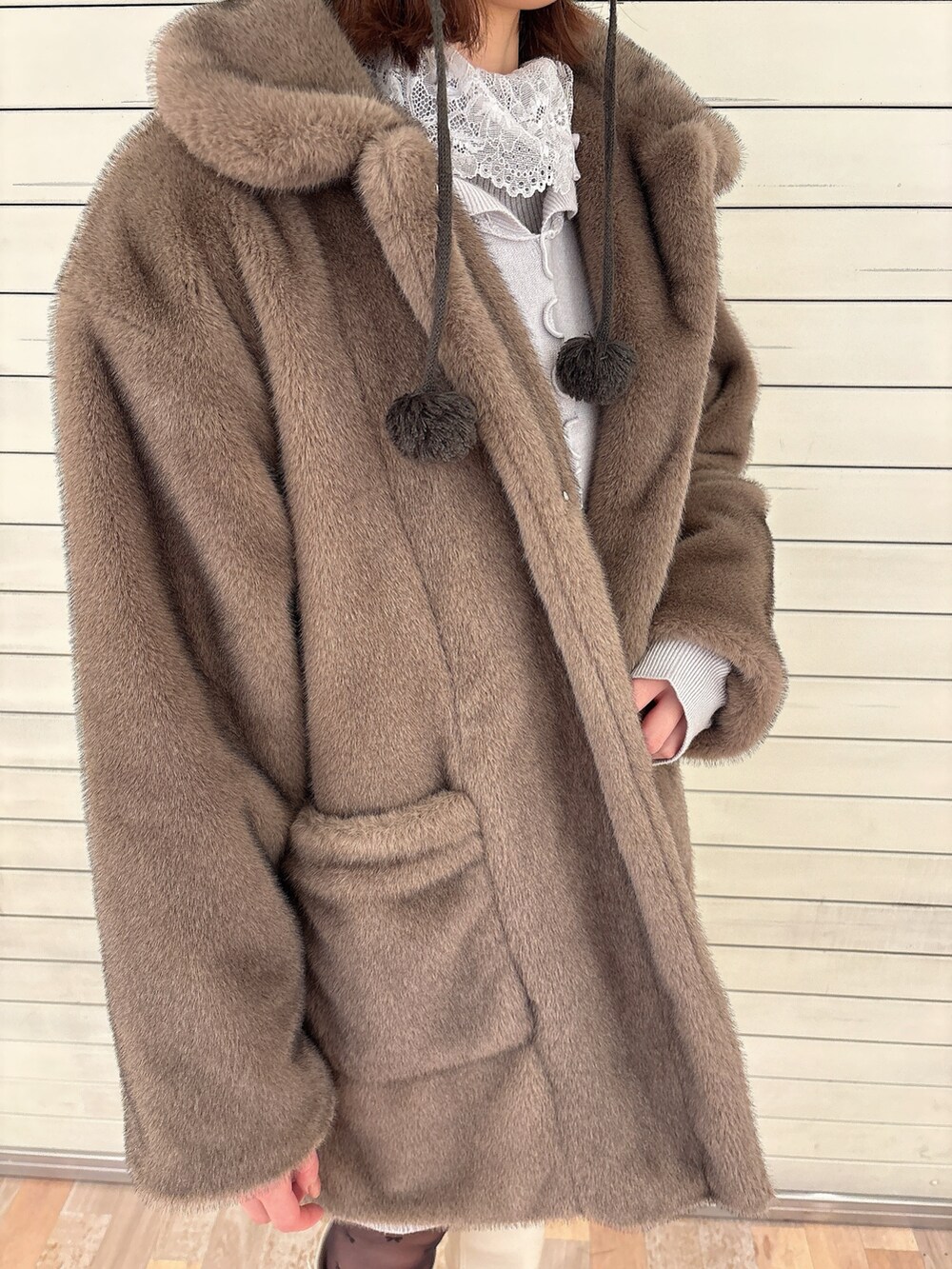 グレー系のニット/セーター、ブラウン系のノーカラーコート、ブルー系のワンピースを着用したレディースの冬コーディネートの5枚目の写真