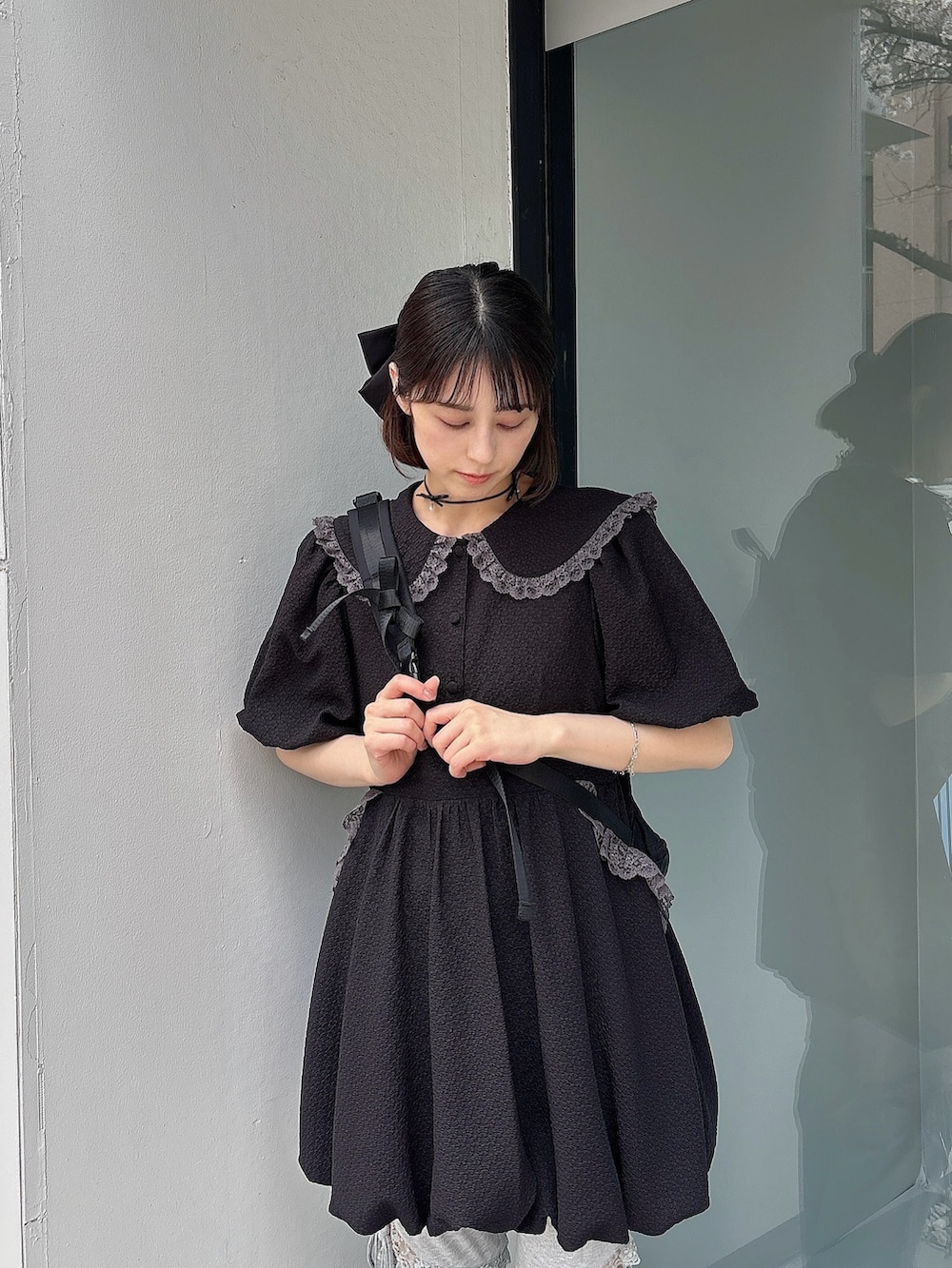 グレー系のスウェットパンツ、ブラック系のスニーカー、ブラック系のワンピースを着用したレディースの春コーディネートの3枚目の写真