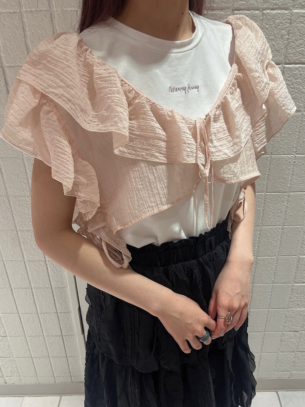 ブラック系のスカート、ゴールド系のパンプス、ホワイト系のTシャツ/カットソーを着用したレディースの夏コーディネートの3枚目の写真