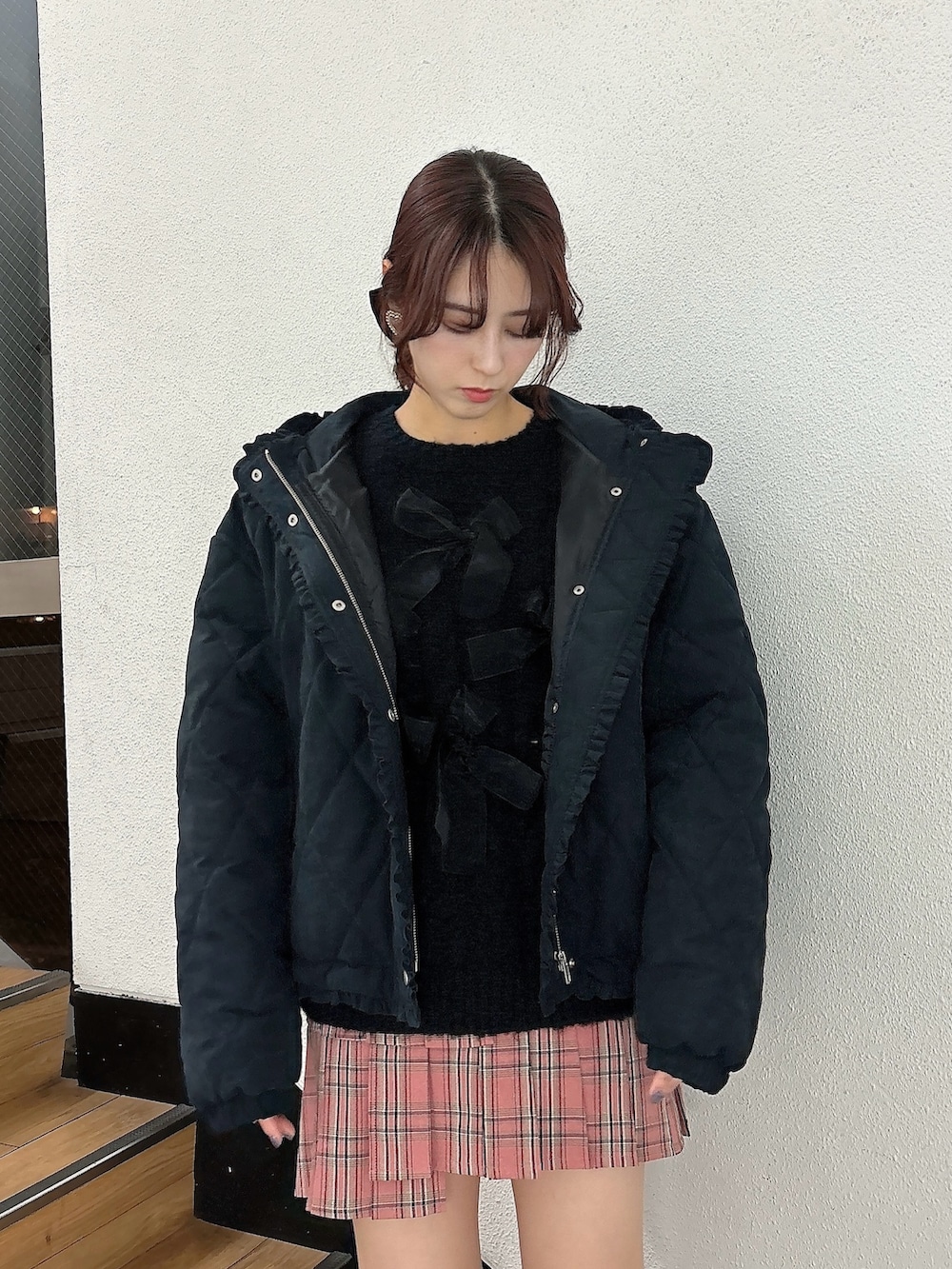 ピンク系のスカート、ブラウン系のブーツ、ブラック系のダウンジャケット/コートを着用したレディースの冬コーディネートの3枚目の写真