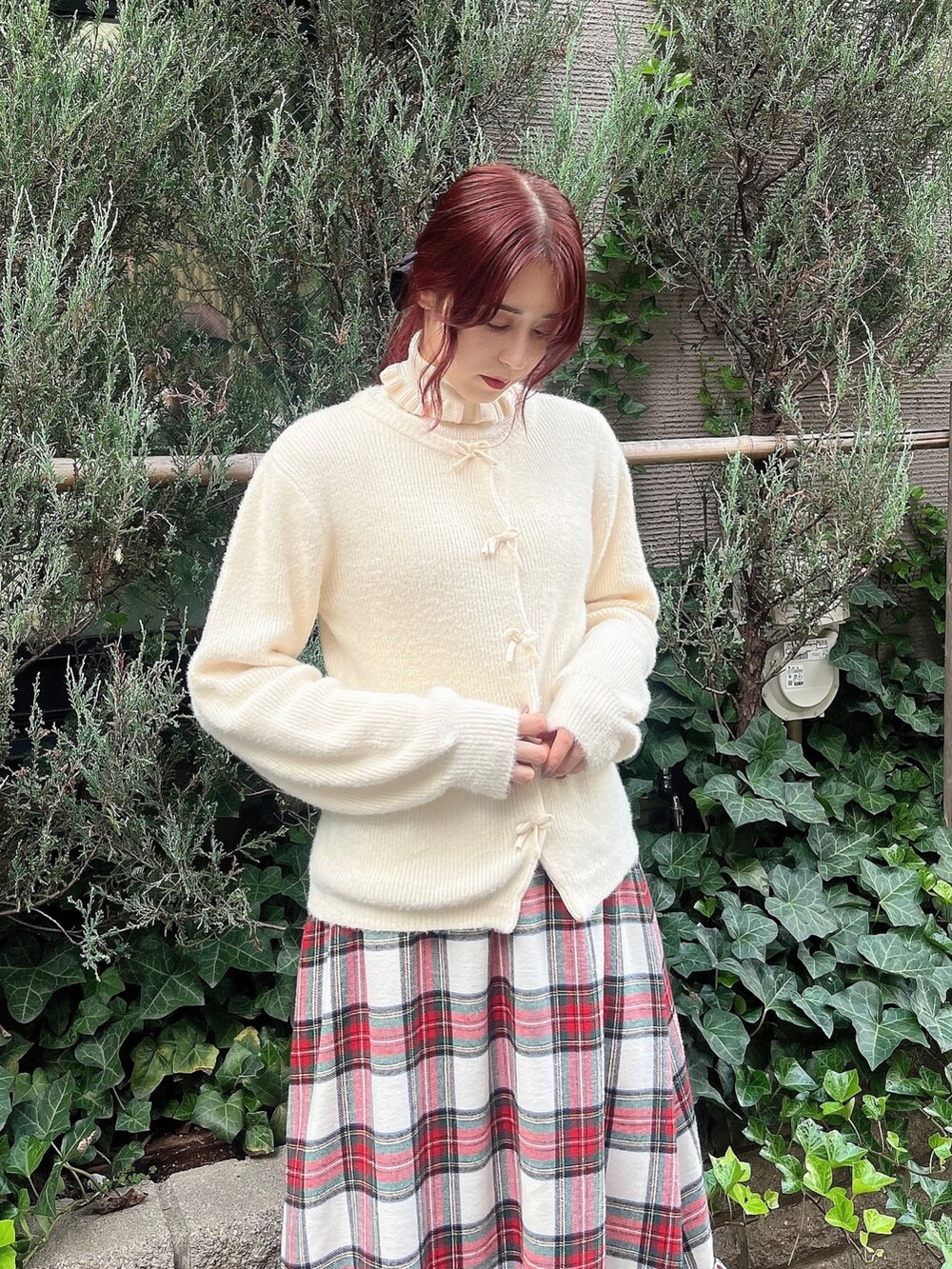 ホワイト系のブーツ、ホワイト系のスカート、レッド系のチェスターコートを着用したレディースの秋コーディネートの4枚目の写真