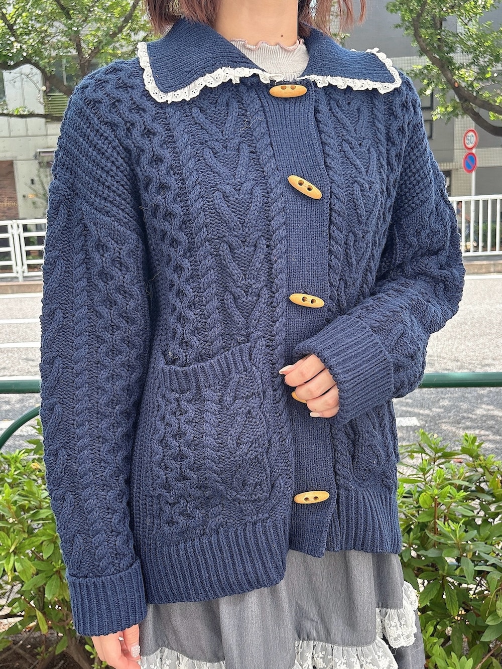 グレー系のスカート、ブルー系のカーディガン/ボレロ、ホワイト系のショルダーバッグを着用したレディースの夏コーディネートの6枚目の写真